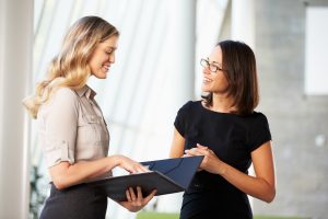 Two Businesswomen Having Informal Meeting In Modern Office