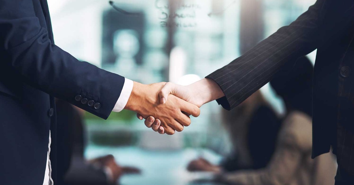 Female and male business people shaking hands after agreeing to new email sending platform contract.